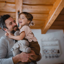 Parent carrying child and stuffed animal.